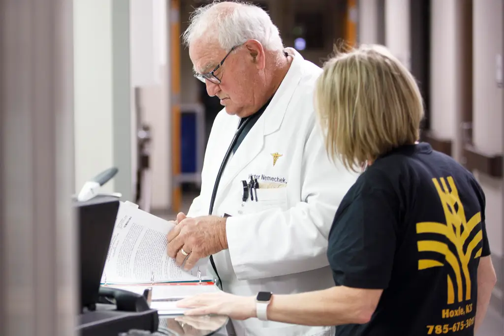 healthcare practitioner speaks with a doctor looking over papers